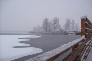 Veduta del Lago di Comabbio ghiacciato e della passerella di legno